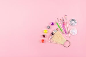 Manicure, gel nail art design equipment, tools and samples on pink background